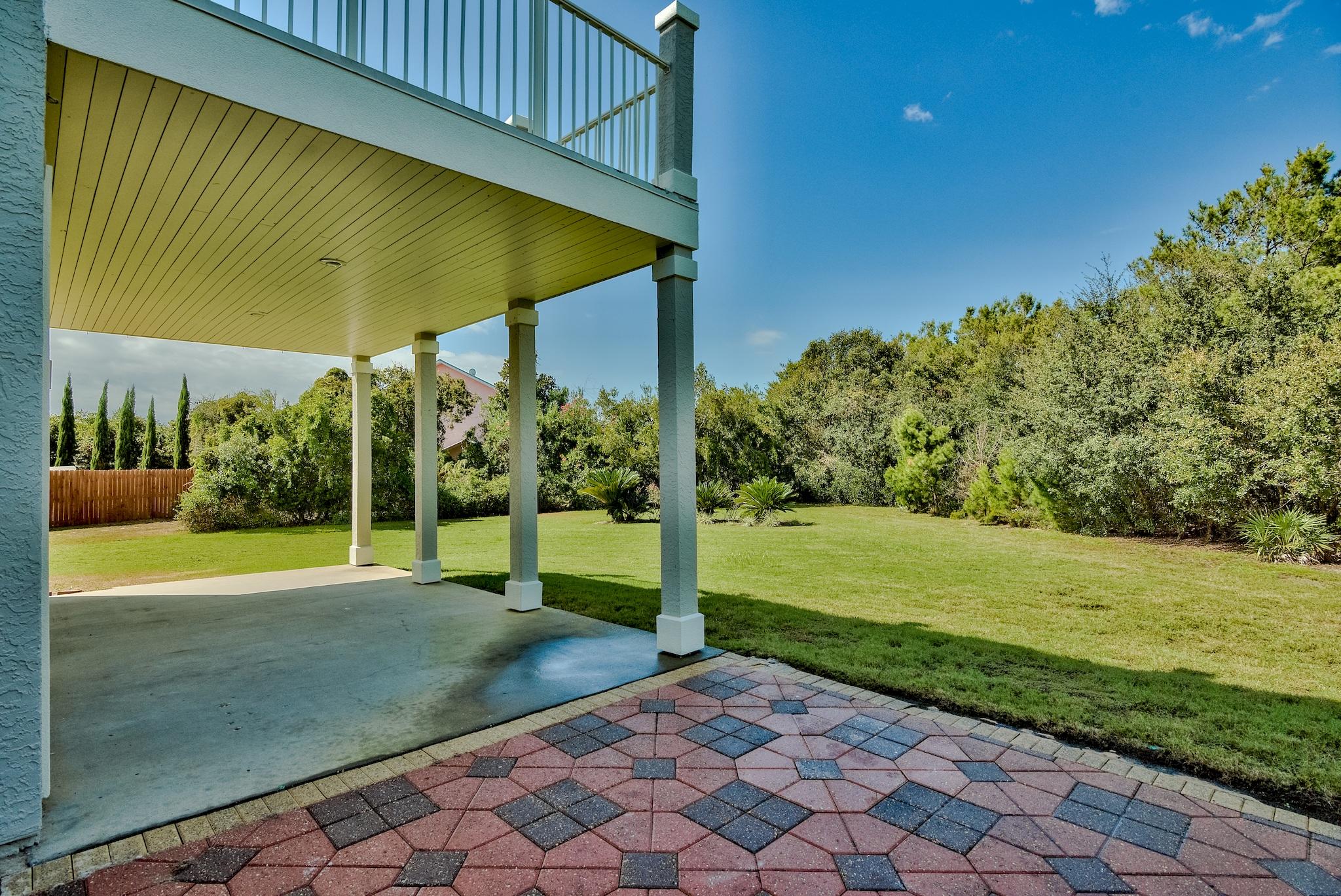 103 Pelican Glide Lane Inlet Beach, FL 32461 - Photo 13 of 47 a view of a backyard with table and chairs under an umbrella