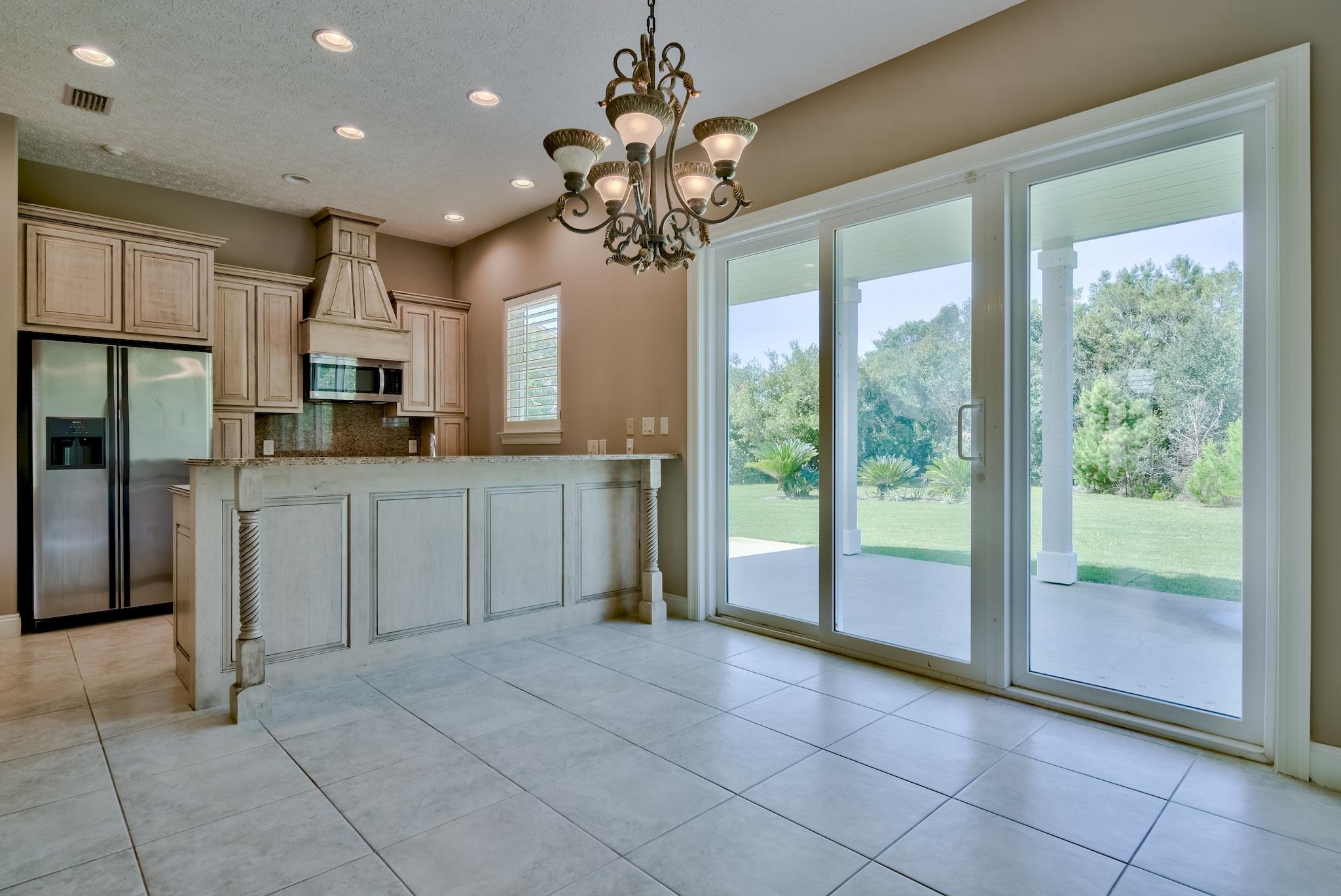 103 Pelican Glide Lane Inlet Beach, FL 32461 - Photo 20 of 47 a open kitchen with granite countertop a refrigerator a sink a counter top space cabinetry and a chandelier