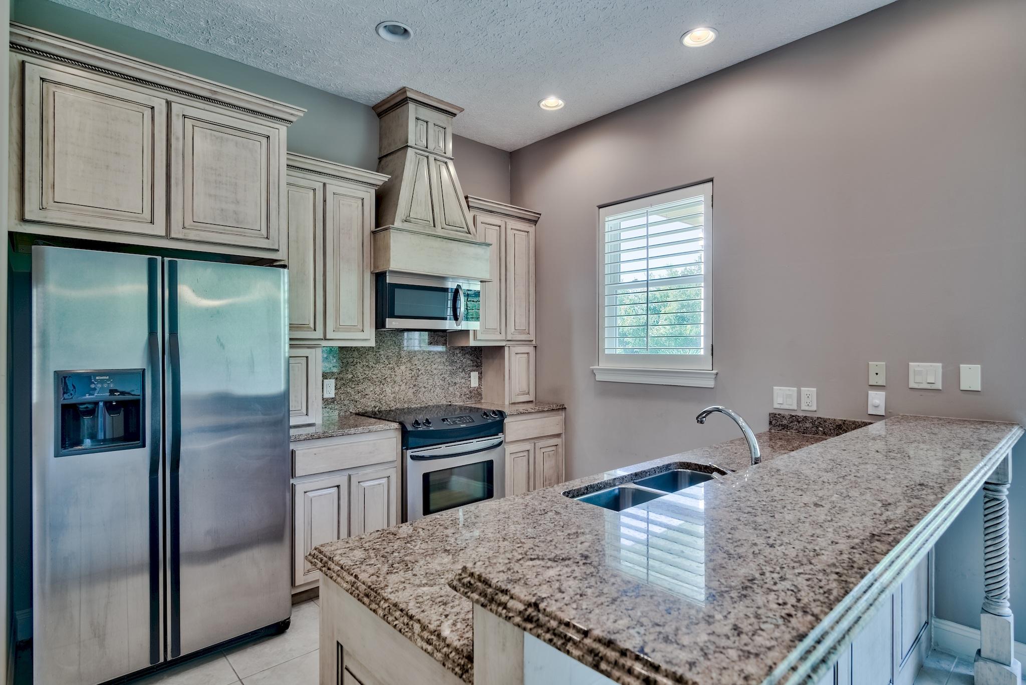 103 Pelican Glide Lane Inlet Beach, FL 32461 - Photo 23 of 47 a kitchen with stainless steel appliances granite countertop a sink stove and refrigerator