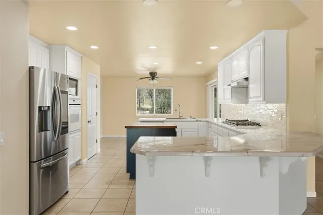 a kitchen with stainless steel appliances granite countertop a refrigerator and a sink