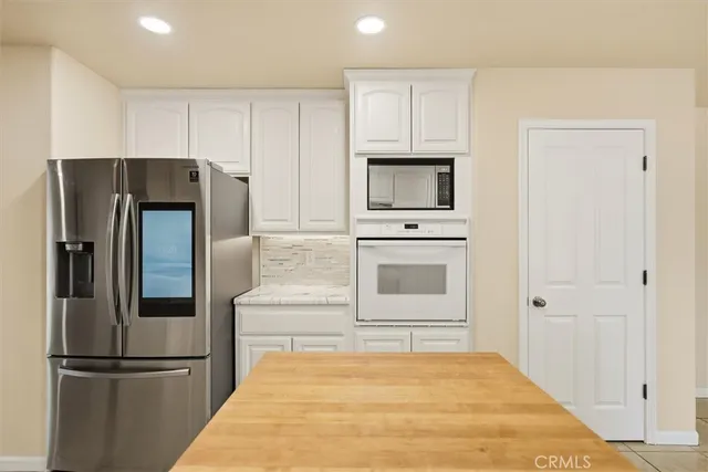 a kitchen with stainless steel appliances granite countertop a refrigerator and a stove top oven