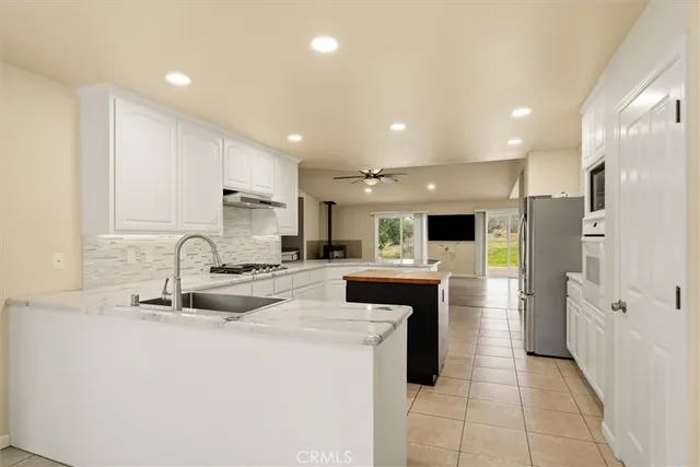 a kitchen with stainless steel appliances kitchen island granite countertop a sink and cabinets