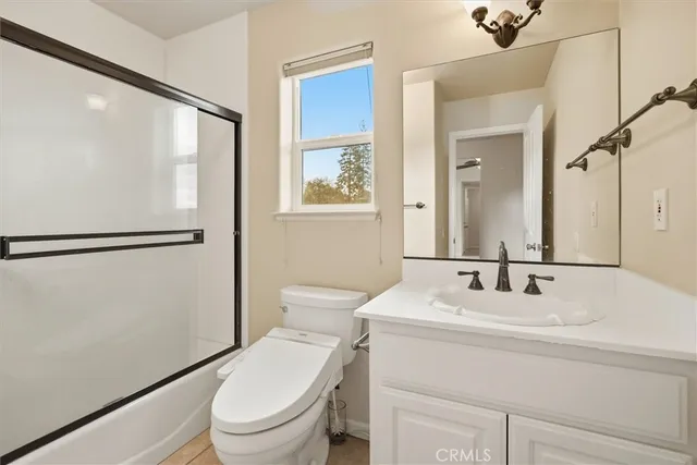 a bathroom with a sink a mirror a toilet and a shower