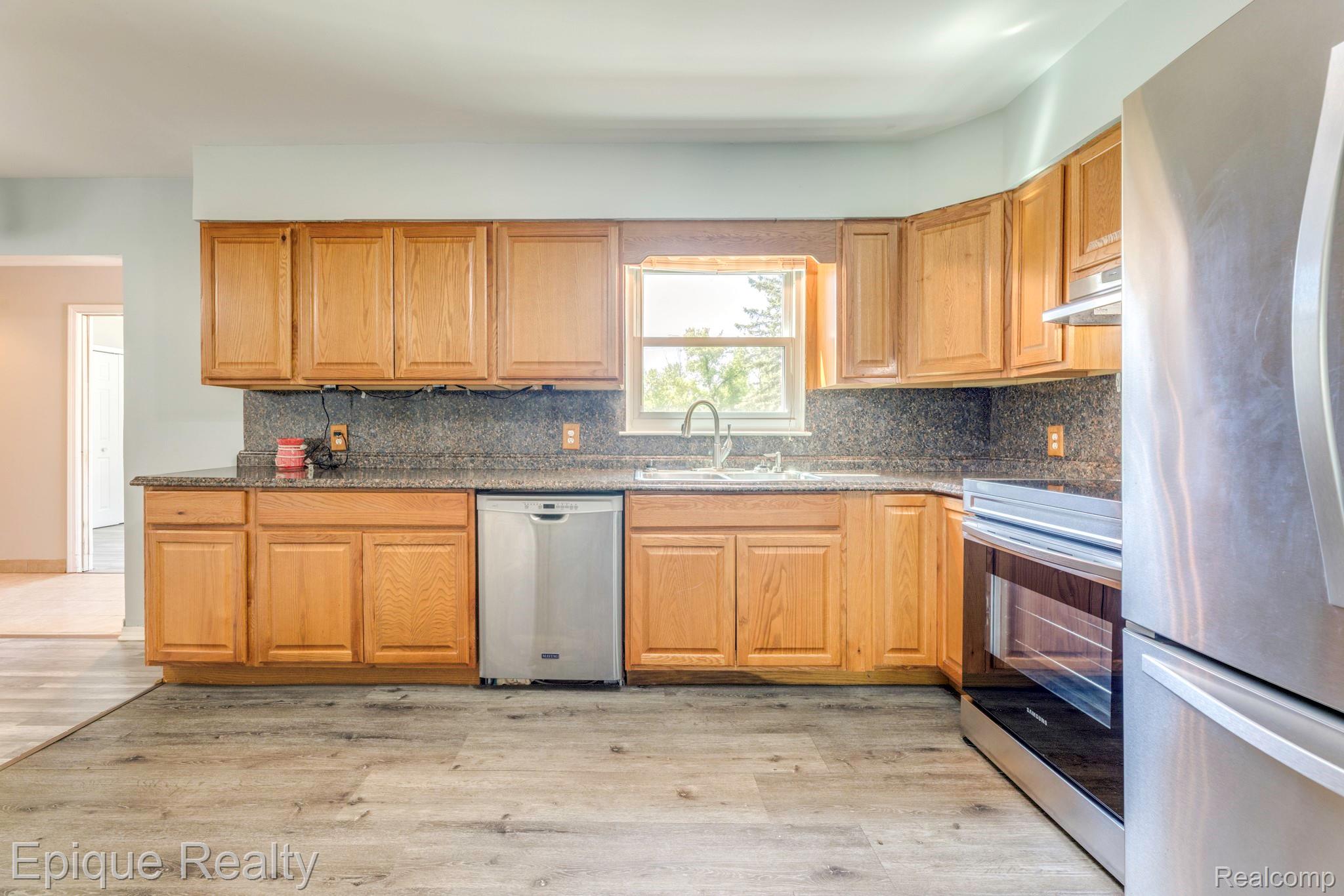 11110 Davison Road Davison, MI 48423 - Photo 20 of 65 Kitchen featuring stainless steel appliances, light wood-style flooring, backsplash, and dark stone countertops
