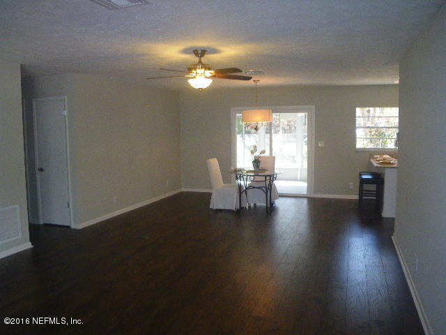 402 Jasmine Road St. Augustine, FL 32086 - Photo 3 of 33 a dining room with wooden floor a chandelier a glass table and chairs