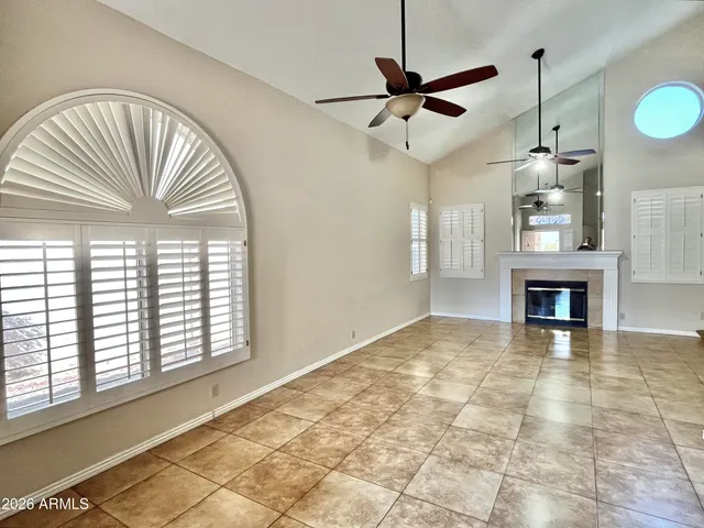 a view of an empty room with a window and fireplace