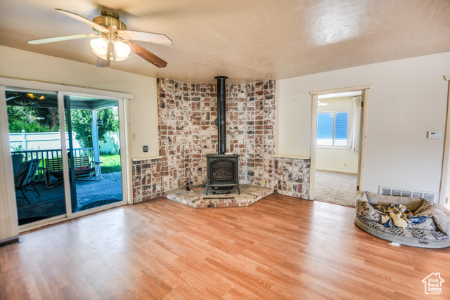 2373 East 190 North Beaver, UT 84713 - Photo 27 of 54 Living area with a wood stove, wood finished floors, ceiling fan, and a textured ceiling