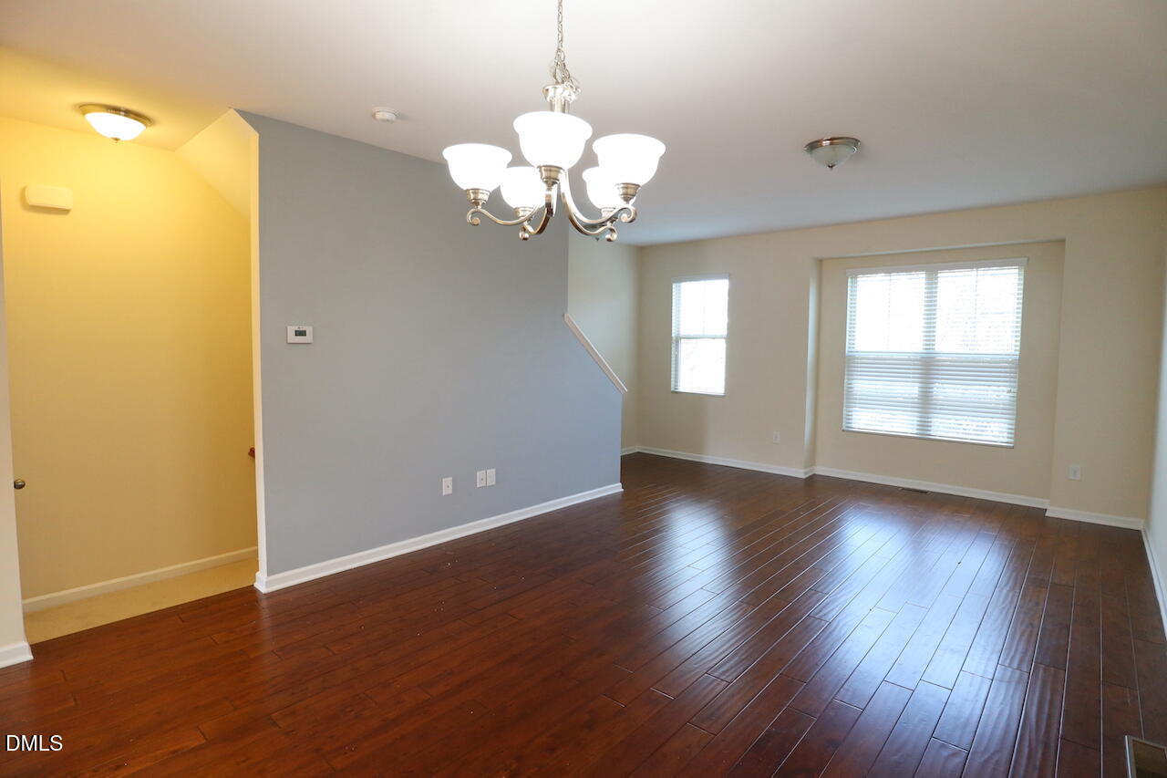 1517 Crafton Way Raleigh, NC 27607 - Photo 4 of 28 a view of an empty room with wooden floor and a window