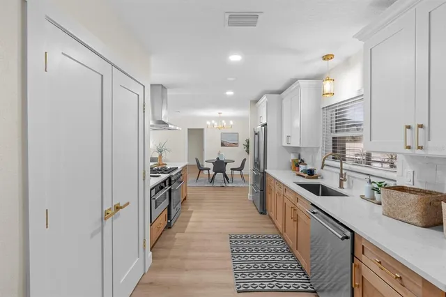 a kitchen with stainless steel appliances granite countertop a sink stove and refrigerator