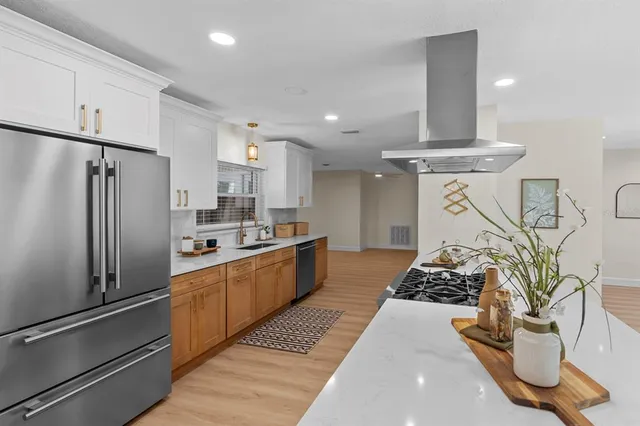 a kitchen with stainless steel appliances granite countertop a sink stove and refrigerator