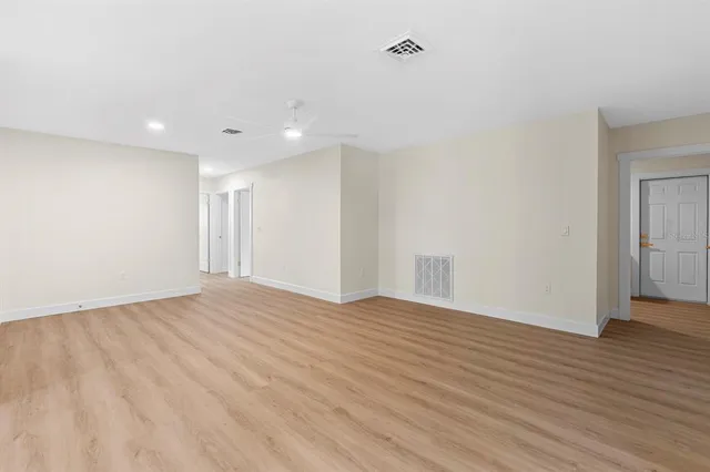 a view of an empty room with wooden floor