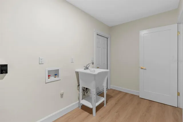 a backyard of a house with table and chairs plants and large tree