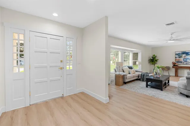 a living room with furniture kitchen view and a chandelier