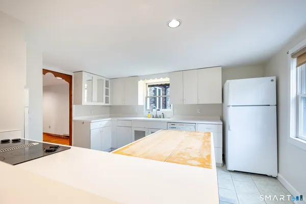 a kitchen with a refrigerator and a stove top oven