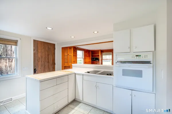 a kitchen with white cabinets and white appliances