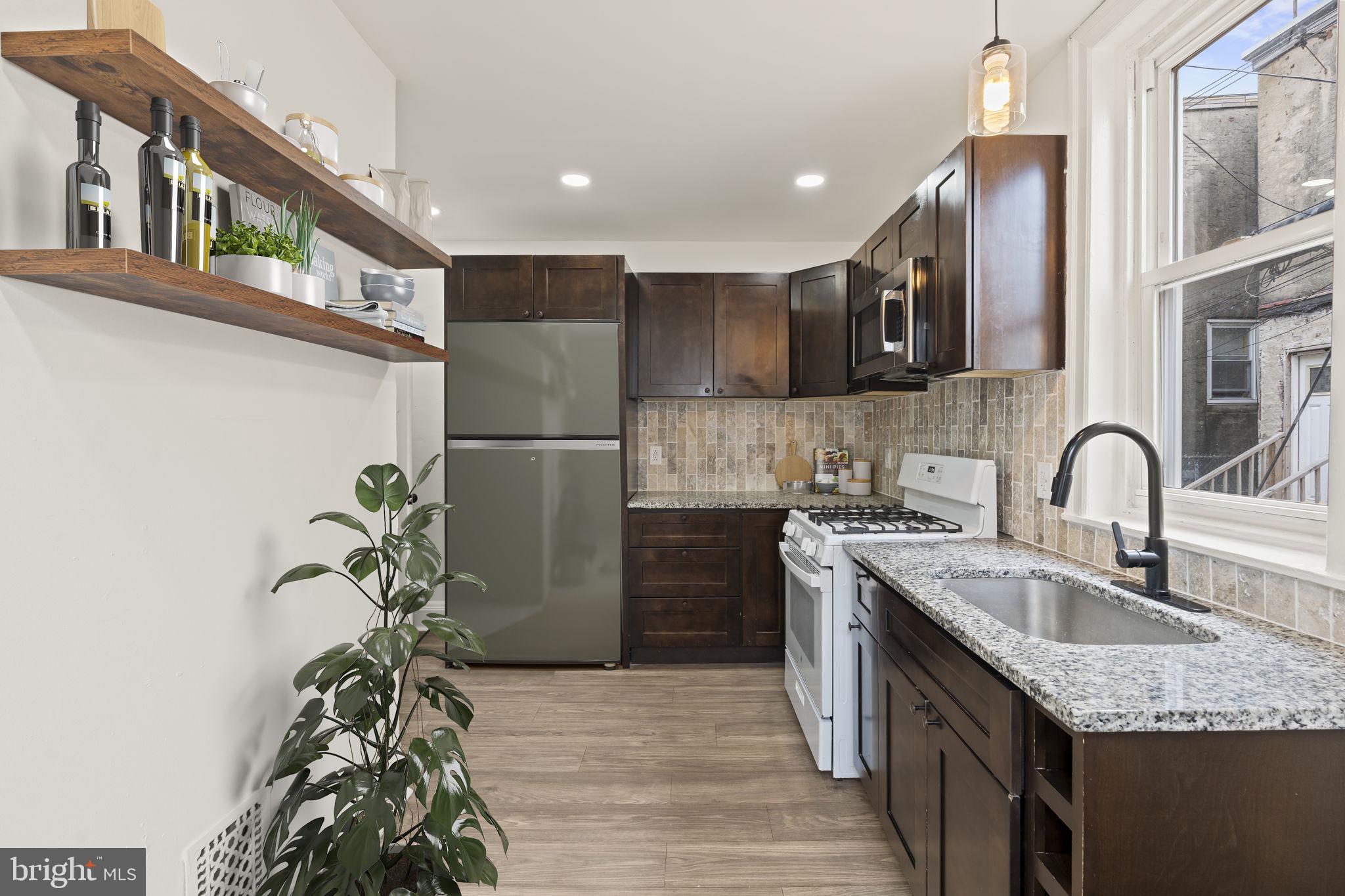4466 North 3rd Street Philadelphia, PA 19140 - Photo 11 of 28 a kitchen with stainless steel appliances granite countertop a sink a stove and a refrigerator