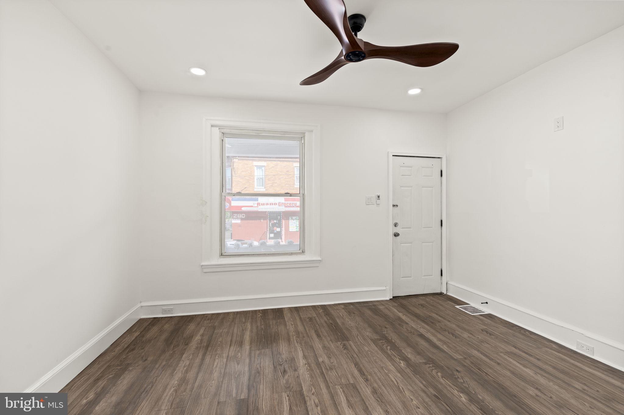 4466 North 3rd Street Philadelphia, PA 19140 - Photo 6 of 28 an empty room with wooden floor ceiling fan and window