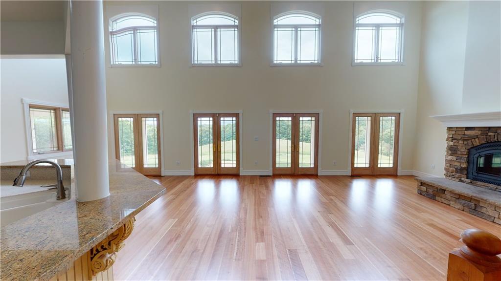 124 Welter Road Butler, PA 16002 - Photo 10 of 22 a hallway with wooden floor fireplace and windows