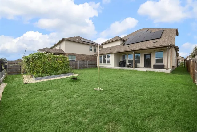a view of a house with a big yard and large trees