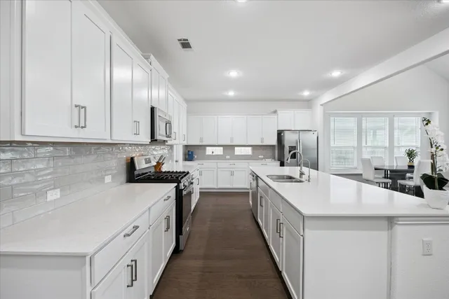a kitchen with two sink and cabinets