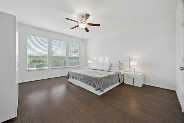 a bedroom with a large bed chandelier and a window