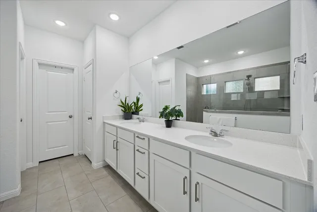 a bathroom with a shower sink and mirror