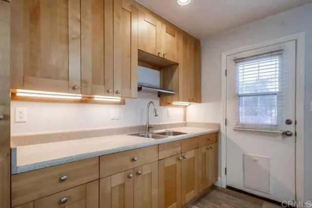 a kitchen with stainless steel appliances granite countertop a sink window and cabinets