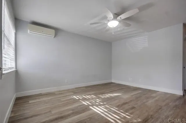 a view of a room with wooden floor and a ceiling fan