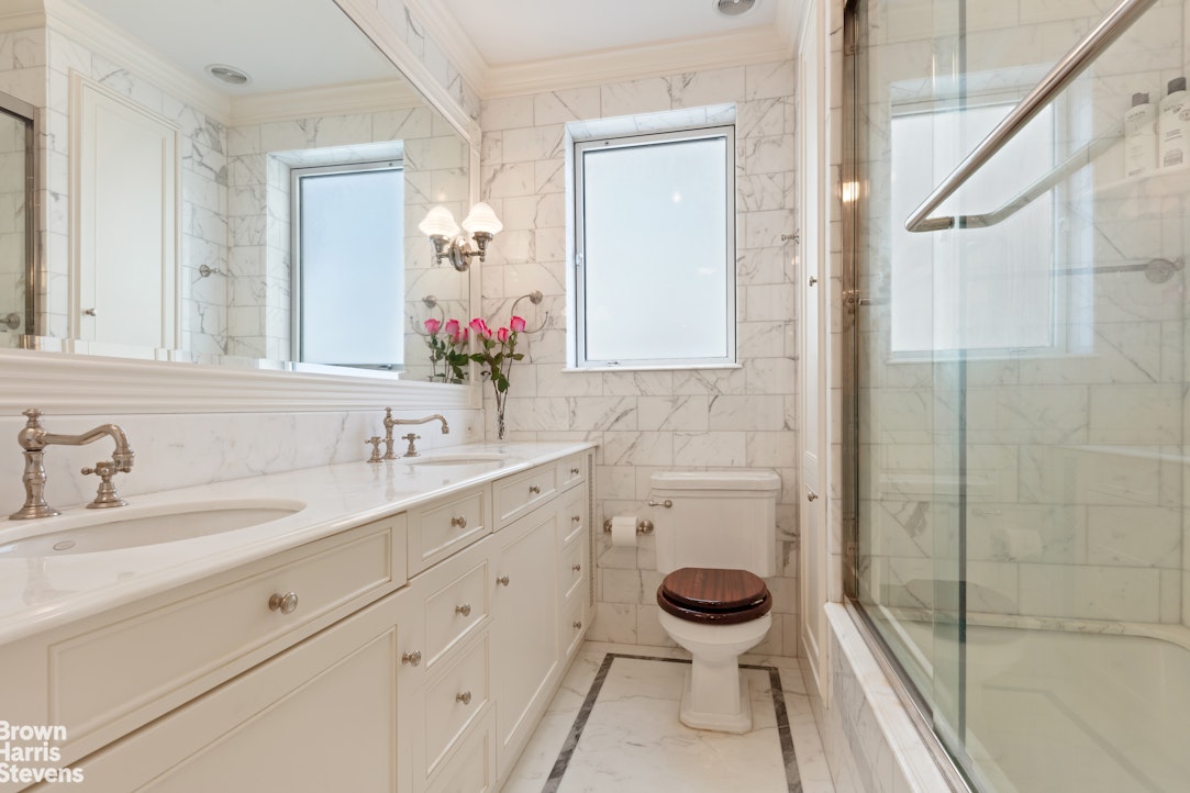 875 Park Avenue, Unit 8C Manhattan, NY 10075 - Photo 11 of 13 a bathroom with a granite countertop sink toilet mirror and a shower