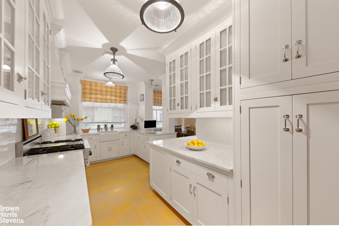 875 Park Avenue, Unit 8C Manhattan, NY 10075 - Photo 6 of 13 a kitchen with stainless steel appliances granite countertop a sink a stove cabinets and a window
