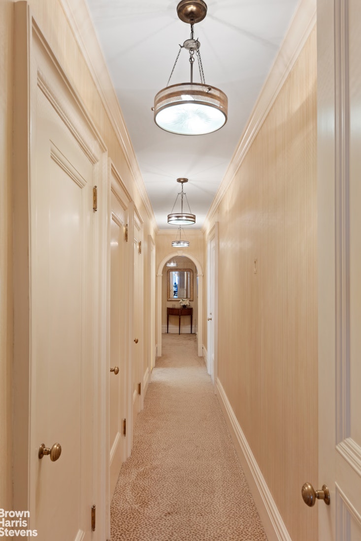 875 Park Avenue, Unit 8C Manhattan, NY 10075 - Photo 8 of 13 a view of a hallway with a chandelier