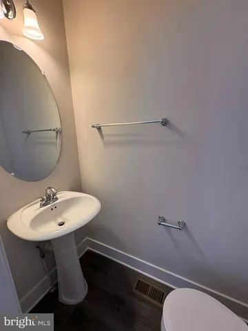 a bathroom with a toilet a sink and mirror