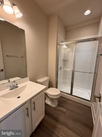 a bathroom with a sink a toilet a mirror and shower
