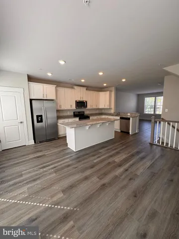 a view of kitchen with refrigerator stove microwave and cabinets