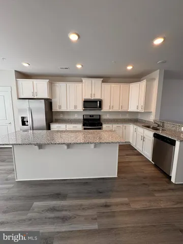 a large kitchen with granite countertop a stove top oven a sink and dishwasher a granite counter top