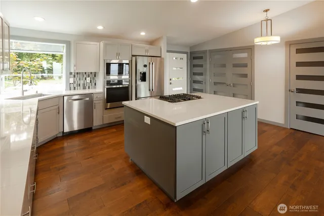 a kitchen with a stove a refrigerator and a oven