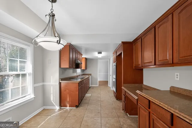 a kitchen with stainless steel appliances granite countertop a refrigerator a stove top oven and a sink with granite countertops