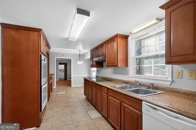 a kitchen with stainless steel appliances granite countertop a sink stove and cabinets