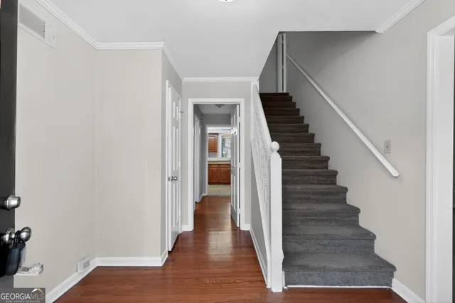 a view of a hallway with wooden floor and entryway