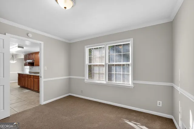 an empty room with a window and a kitchen