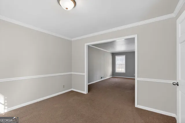 a view of an empty room with wooden floor and windows