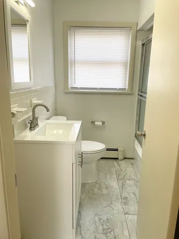 a bathroom with a sink toilet and mirror
