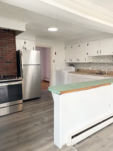 a kitchen with a refrigerator sink and cabinets