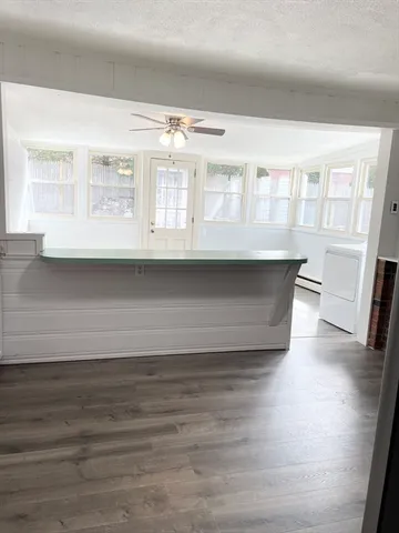 a living room with wooden floor and large window