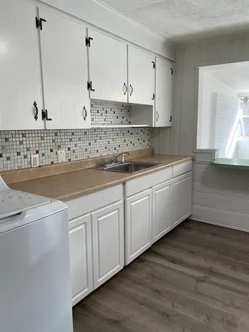 a kitchen with granite countertop white cabinets and white appliances