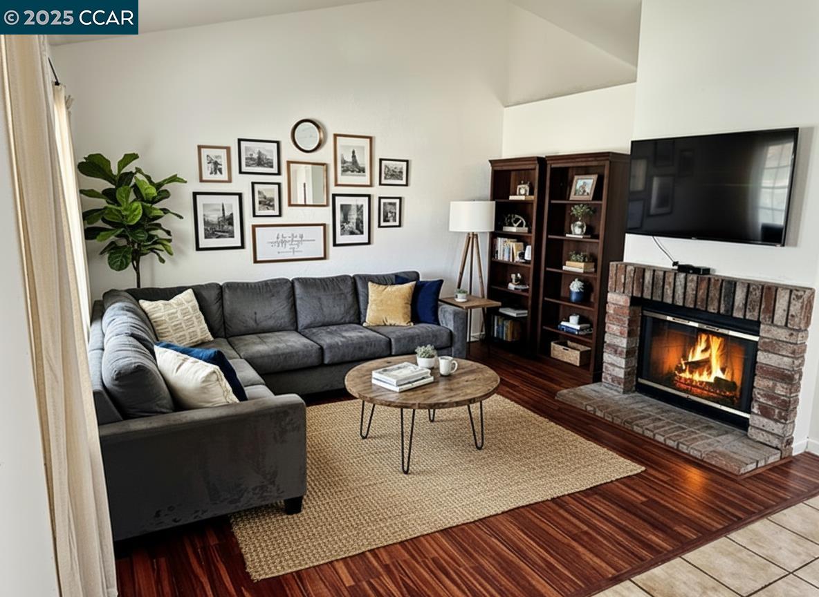 a living room with furniture a flat screen tv and a fireplace
