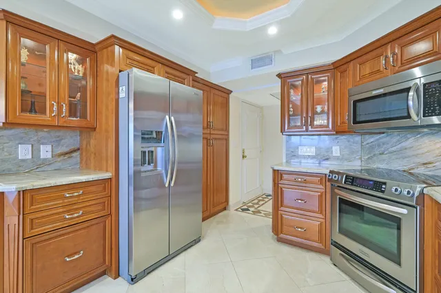 a kitchen with stainless steel appliances granite countertop wooden cabinets a sink and dishwasher