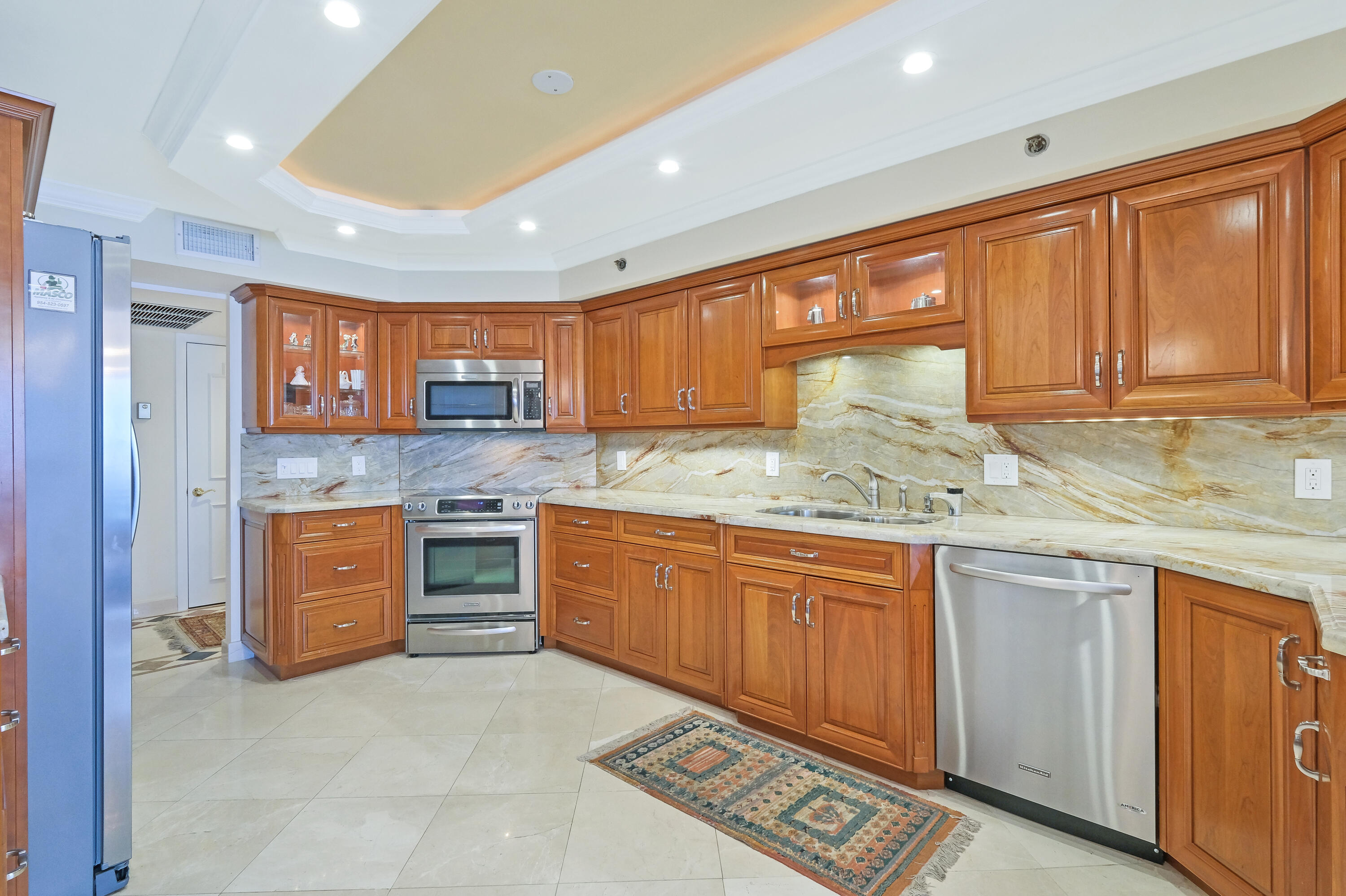 4001 North Ocean Boulevard, Unit B1201 Boca Raton, FL 33431 - Photo 21 of 42 a kitchen with stainless steel appliances granite countertop wooden cabinets a sink and dishwasher