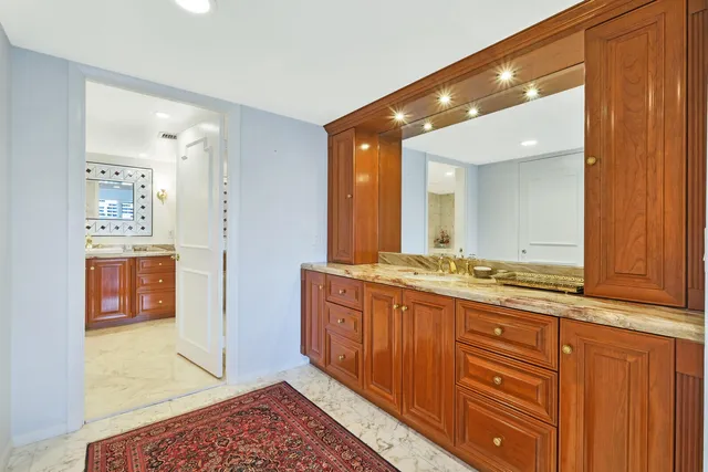 a bathroom with a granite countertop toilet sink and mirror bathtub
