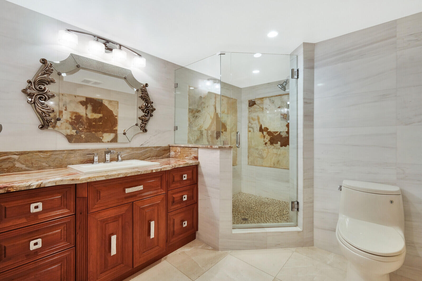 4001 North Ocean Boulevard, Unit B1201 Boca Raton, FL 33431 - Photo 29 of 42 a bathroom with a granite countertop sink a toilet and shower